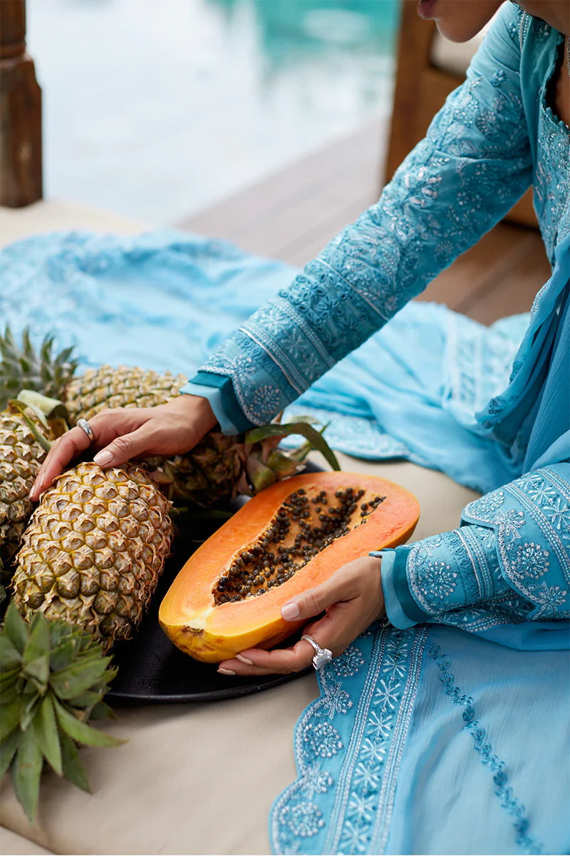 Model wearing Gulaal DHALIA turquoise blue luxury lawn dress with intricate embroidery. Shop Pakistani luxury pret online in the UK.