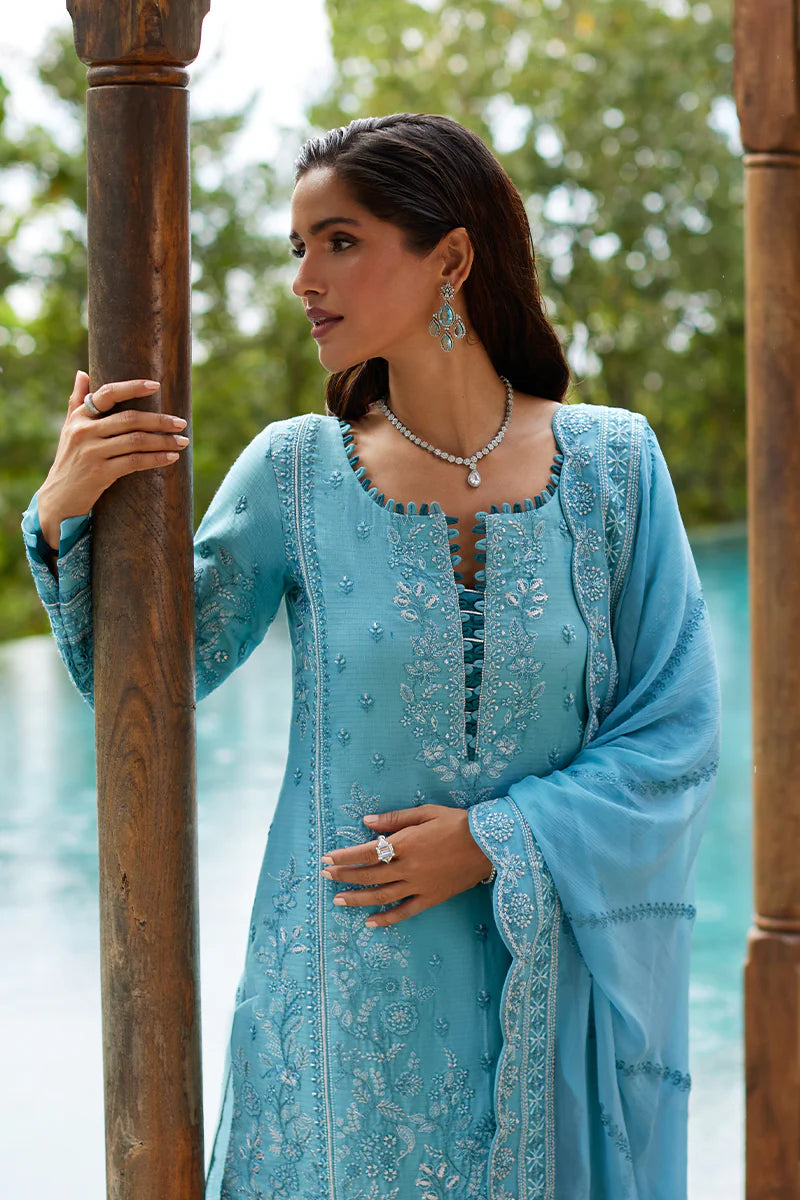 Model wearing Gulaal DHALIA turquoise blue luxury lawn dress with intricate embroidery. Shop Pakistani luxury pret online in the UK.