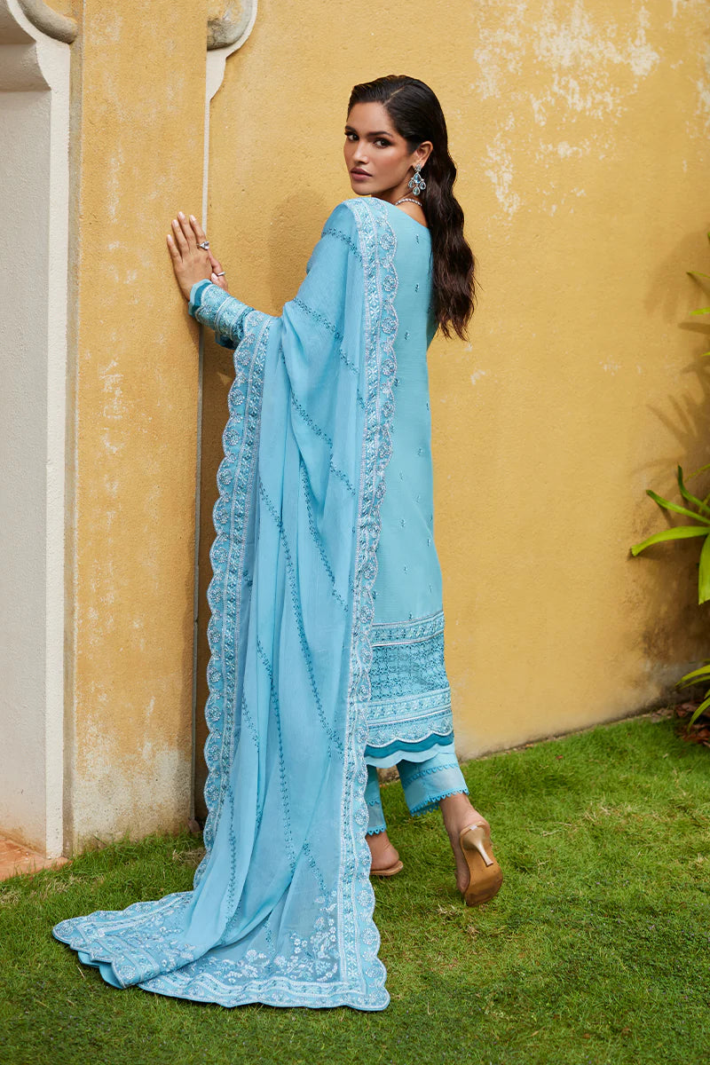 Model wearing Gulaal DHALIA turquoise blue luxury lawn dress with intricate embroidery. Shop Pakistani luxury pret online in the UK.