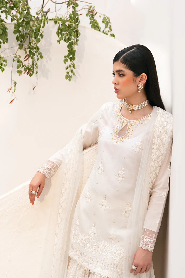 Model wearing Saira Rizwan Amaya dress, elegant white Pakistani clothes UK, detailed Eid wear.