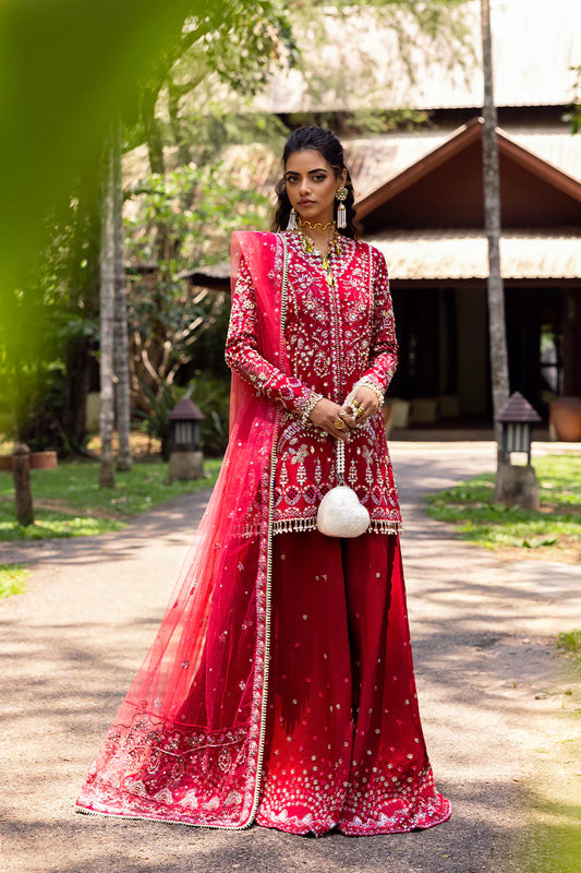 Model wearing Saira Rizwan GOLNAR-SRF25-01 in deep red with gold embellishments – Pakistani luxury pret, shop online in UK.