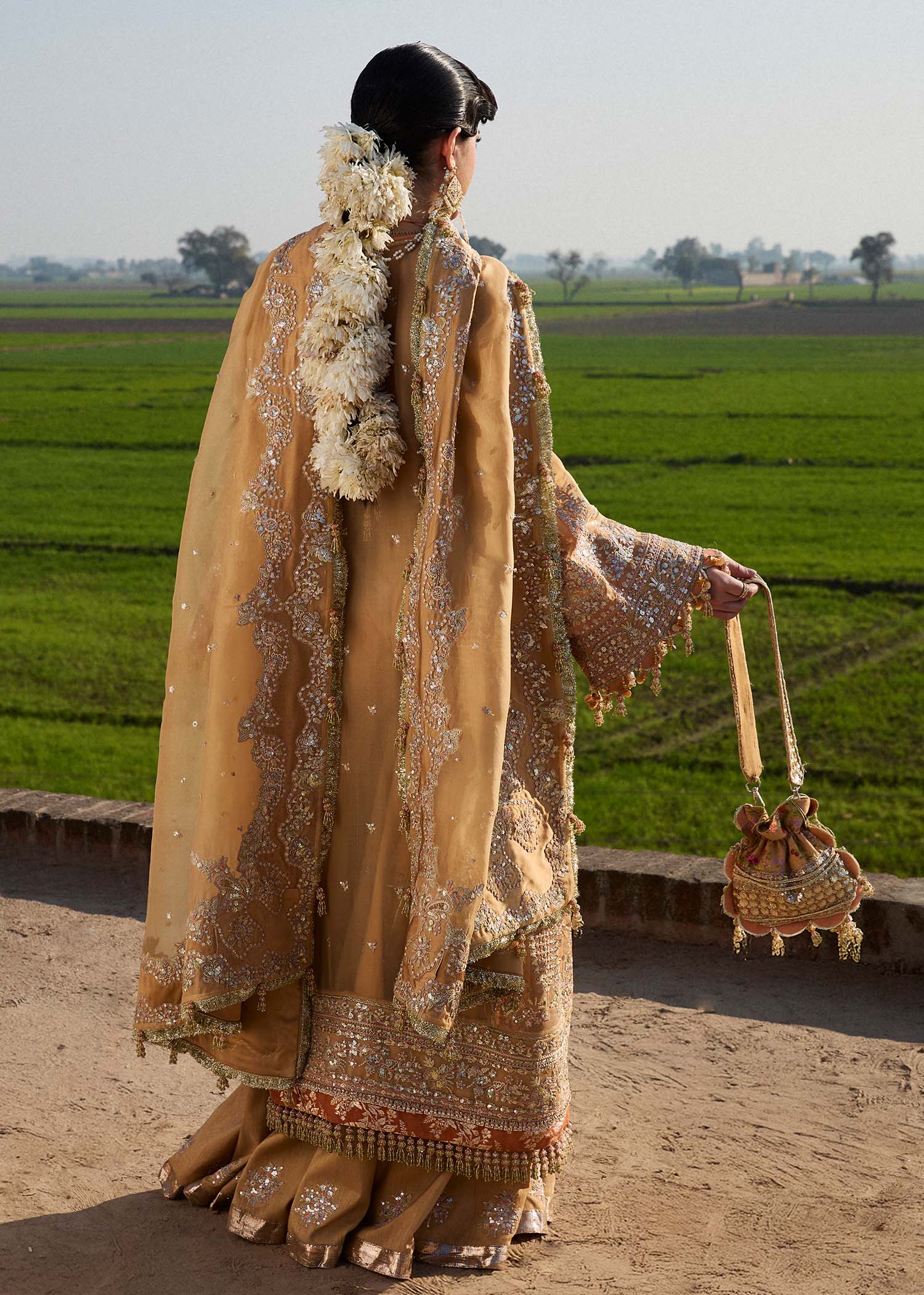 Model wearing Hussain Rehar Sundal golden beige embroidered festive dress with intricate embellishments and traditional details. Shop Pakistani clothes online in the UK now.