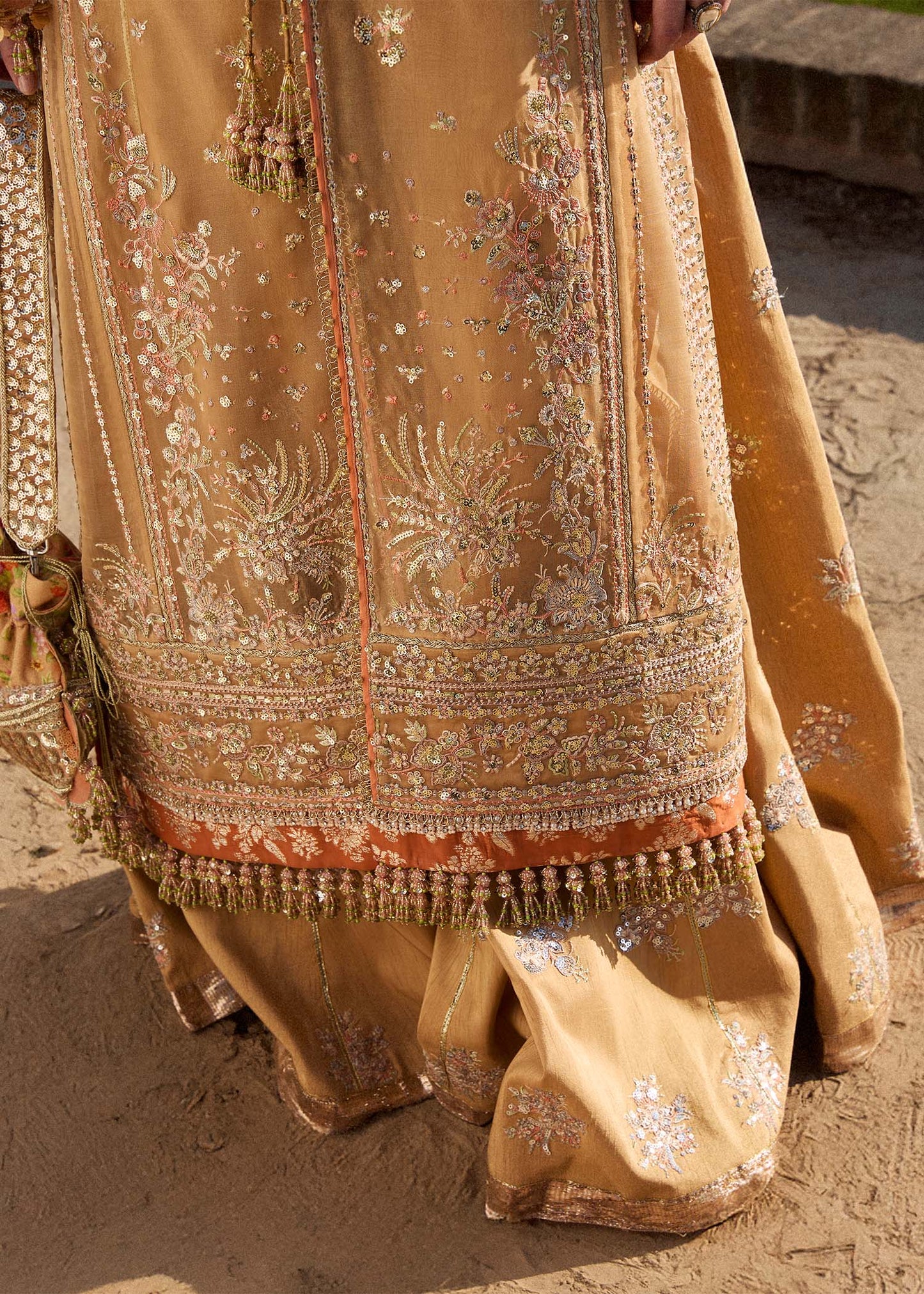 Model wearing Hussain Rehar Sundal golden beige embroidered festive dress with intricate embellishments and traditional details. Shop Pakistani clothes online in the UK now.