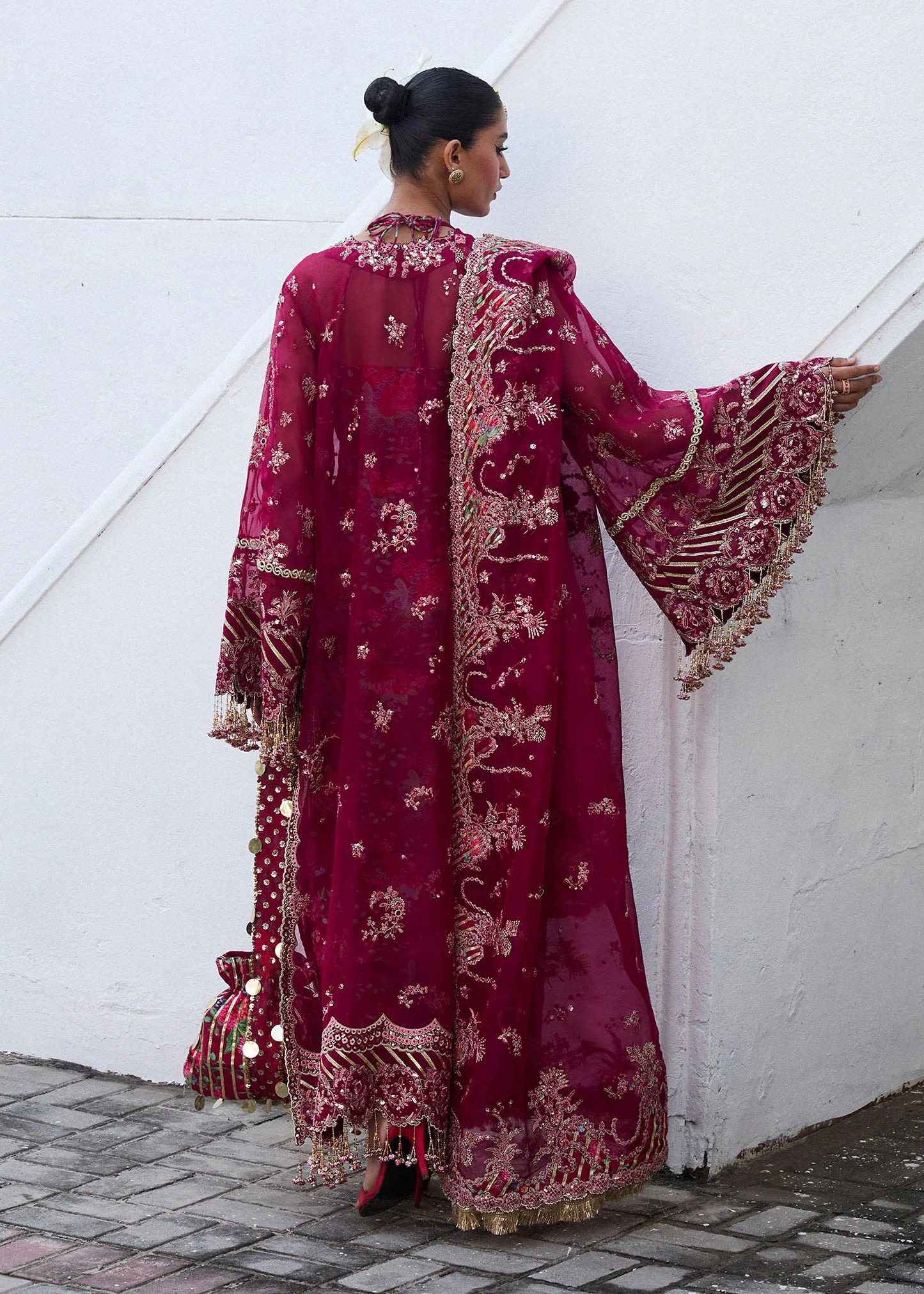 Model wearing Hussain Rehar Maher deep red embroidered festive dress with floral patterns and gold embellishments. Shop Pakistani clothes online in the UK now.