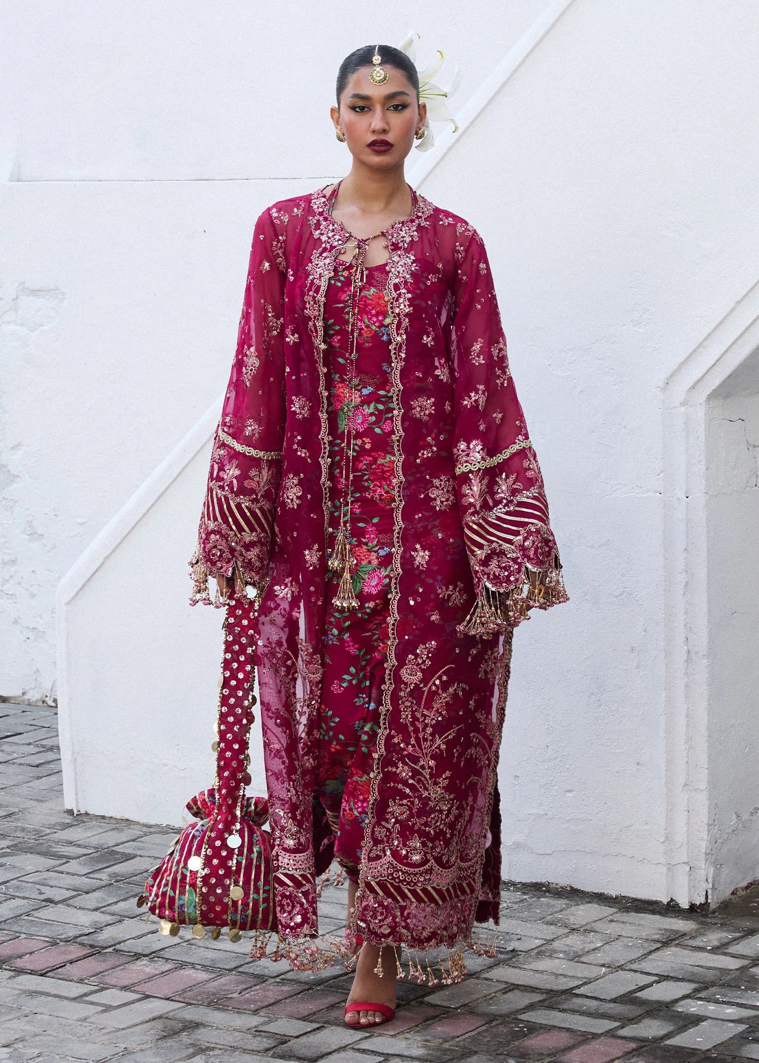 Model wearing Hussain Rehar Maher deep red embroidered festive dress with floral patterns and gold embellishments. Shop Pakistani clothes online in the UK now.