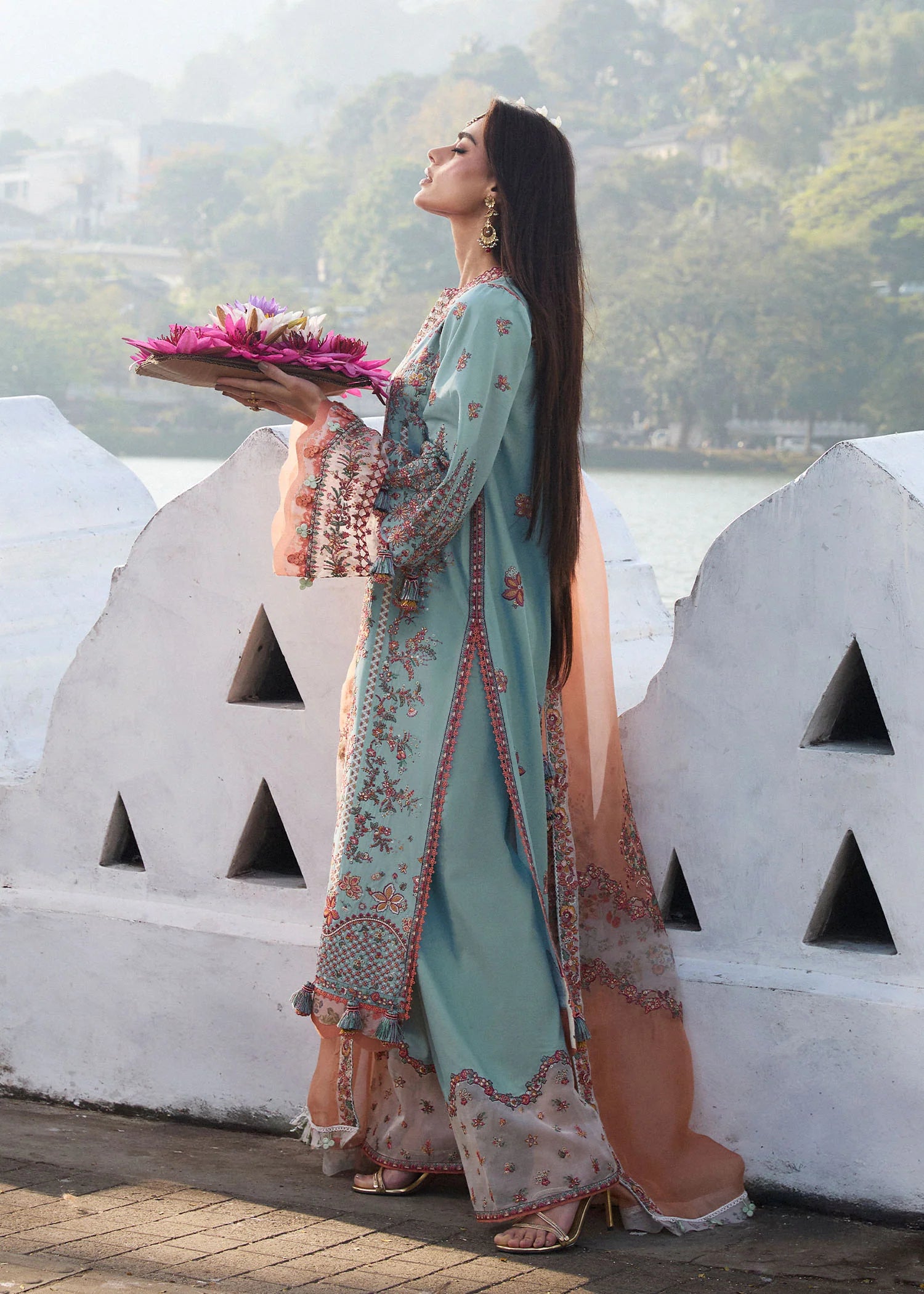 Model wearing Hussain Rehar Luxury Lawn '25 Malibu in turquoise blue with peach dupatta, intricate embroidery. Shop Pakistani luxury pret online in the UK.