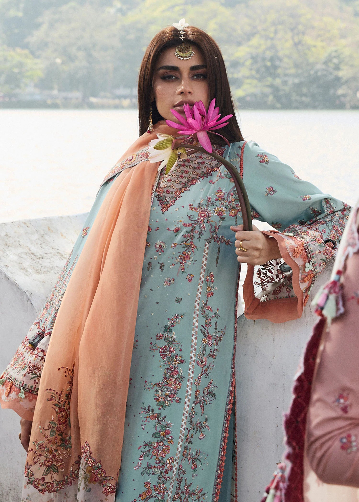 Model wearing Hussain Rehar Luxury Lawn '25 Malibu in turquoise blue with peach dupatta, intricate embroidery. Shop Pakistani luxury pret online in the UK.