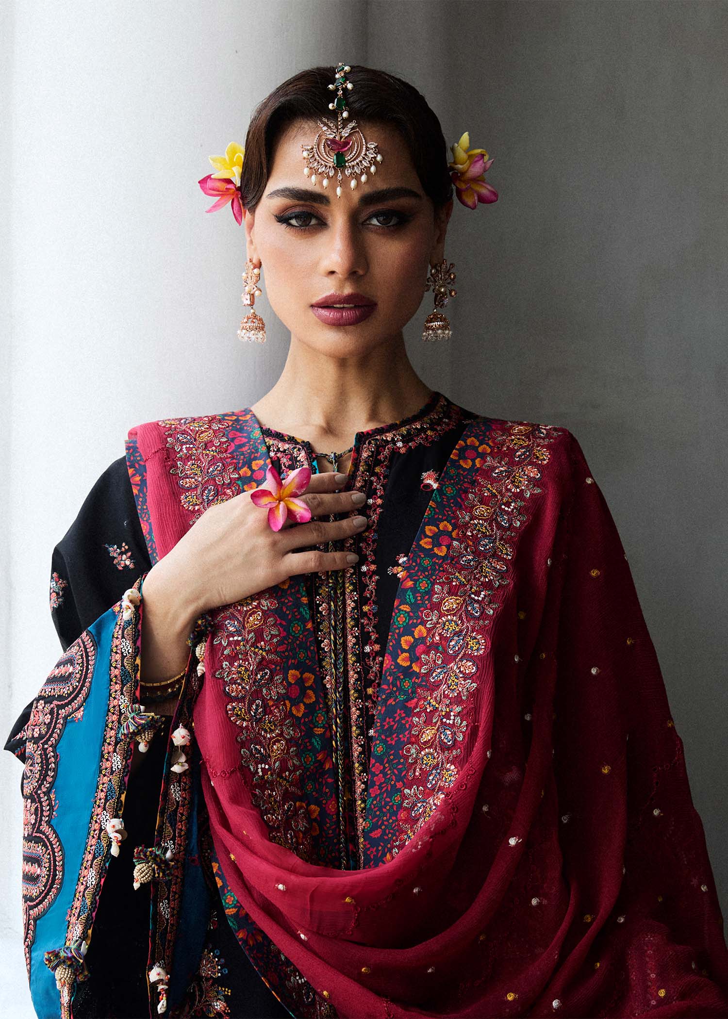 Model wearing Hussain Rehar Luxury Lawn '25 Bliz in black with intricate pink embroidery and a red dupatta. Shop Pakistani luxury pret online in the UK.