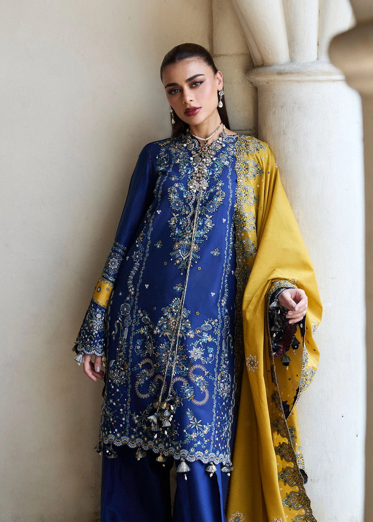 Model wearing Hussain Rehar Luxury Lawn '25 Riviera in royal blue with mustard dupatta, intricate embroidery. Shop Pakistani luxury pret online in the UK.