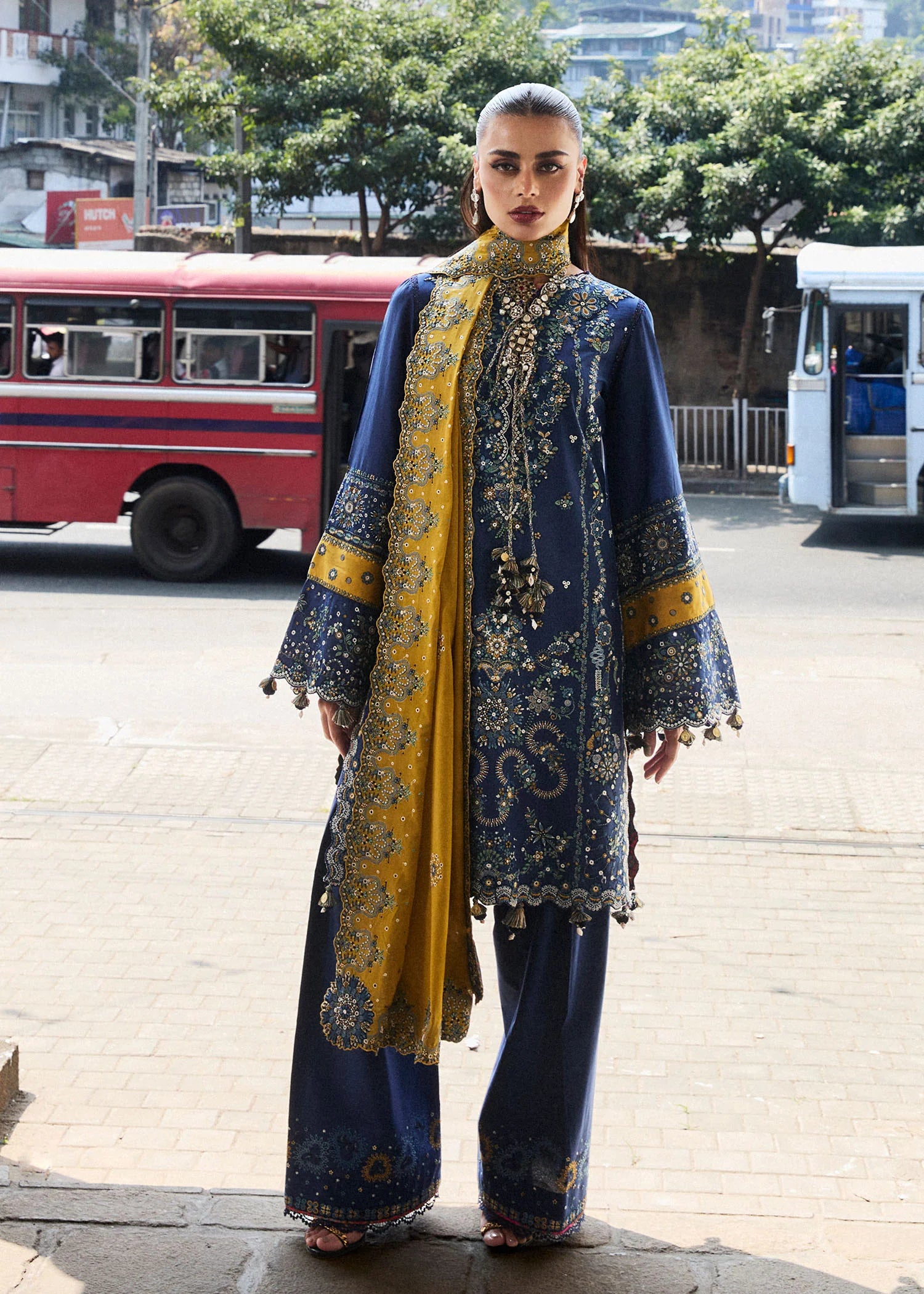 Model wearing Hussain Rehar Luxury Lawn '25 Riviera in royal blue with mustard dupatta, intricate embroidery. Shop Pakistani luxury pret online in the UK.