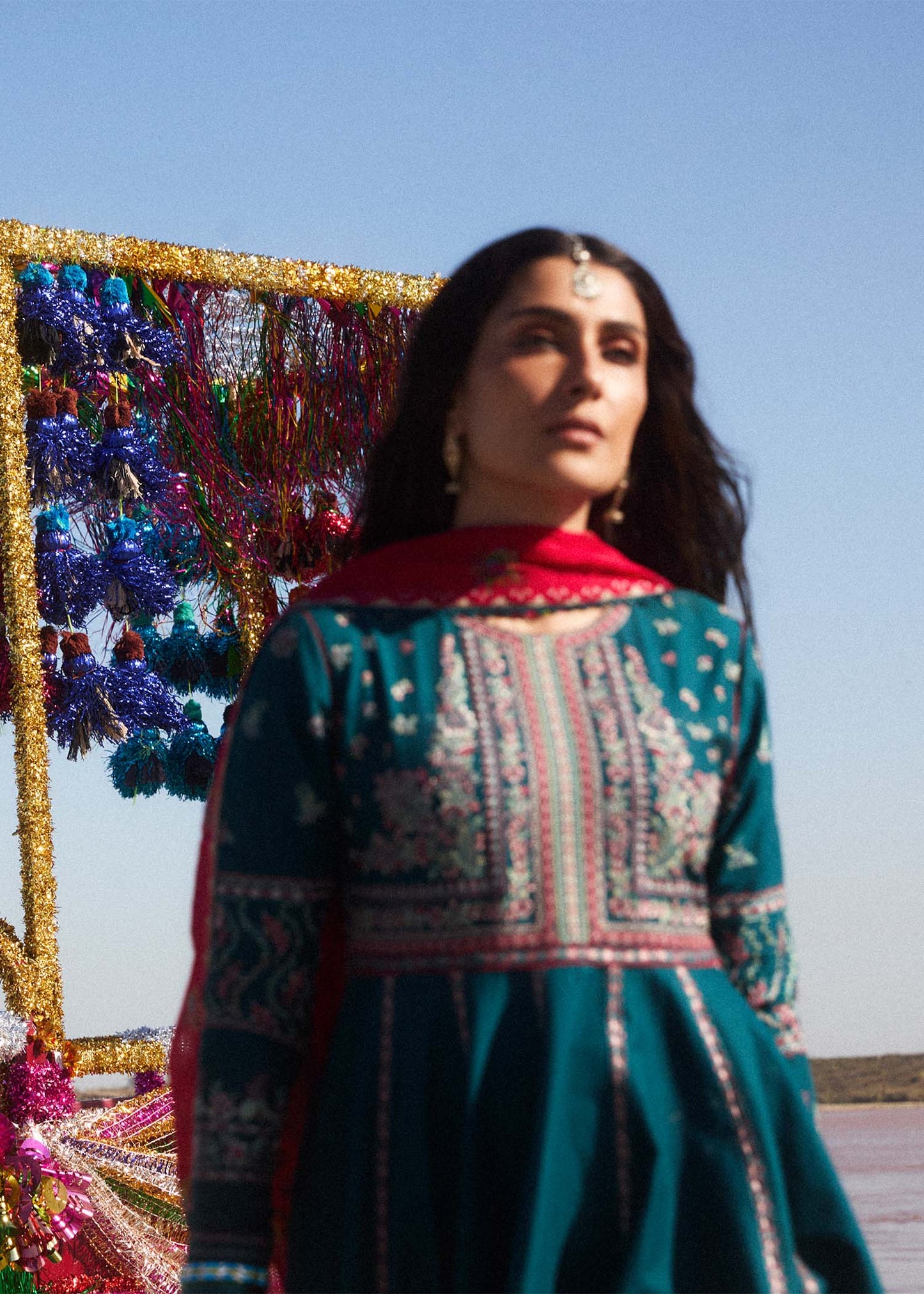 Model wearing teal Zarqash dress from Hussain Rehar with red dupatta, showcasing Pakistani luxury pret and Pakistani clothes online in UK.
