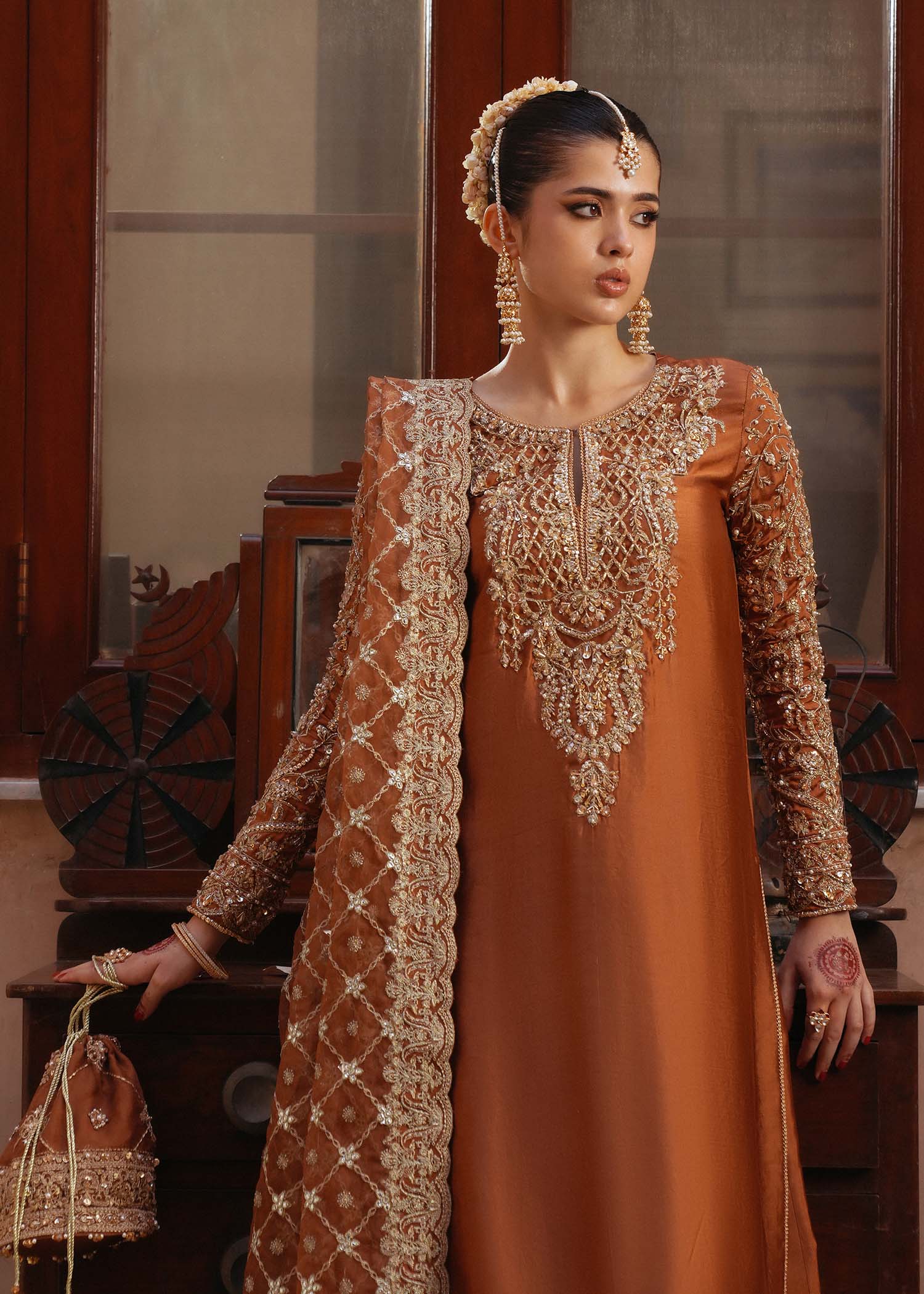 Model wearing Zulekha by Kanwal Malik in rust orange with gold embroidery – timeless Pakistani luxury pret available online in UK.
