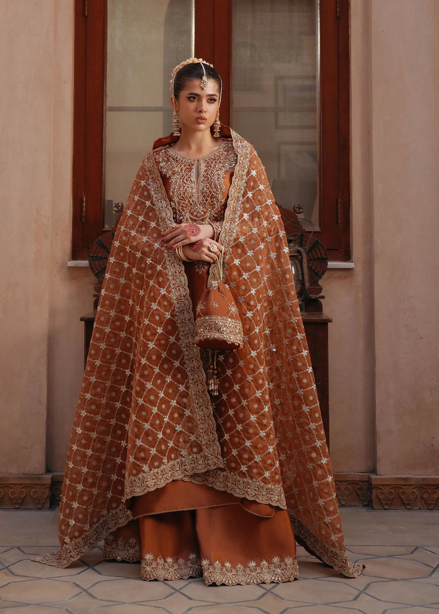 Model wearing Zulekha by Kanwal Malik in rust orange with gold embroidery – timeless Pakistani luxury pret available online in UK.