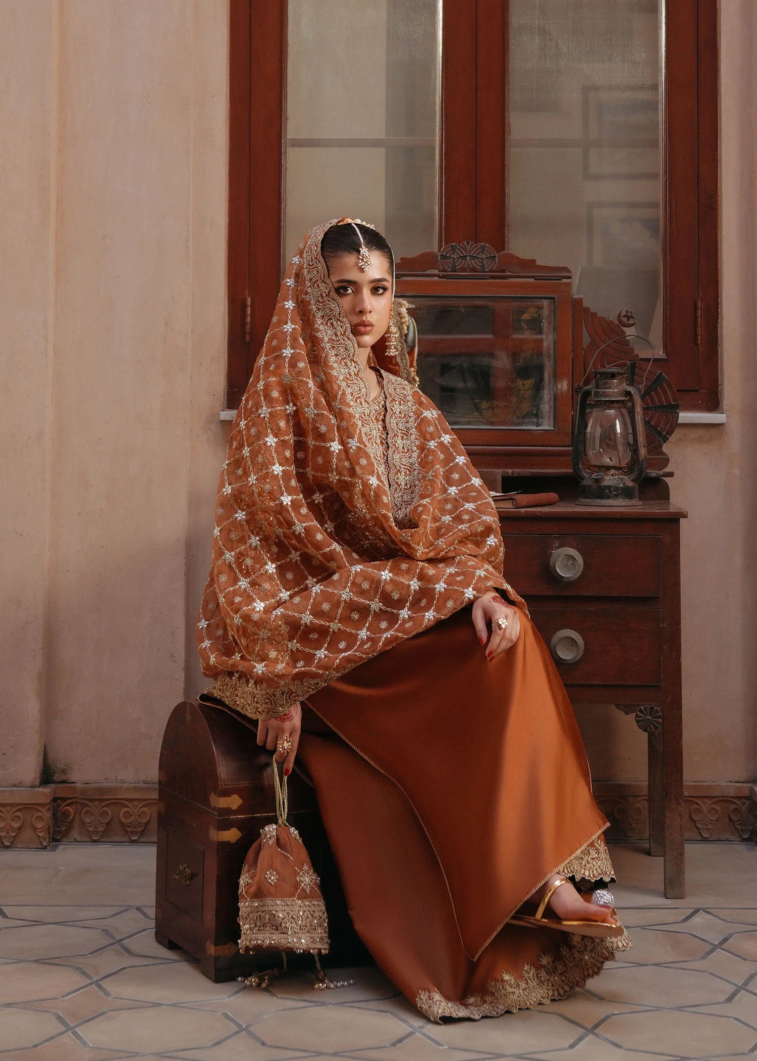 Model wearing Zulekha by Kanwal Malik in rust orange with gold embroidery – timeless Pakistani luxury pret available online in UK.