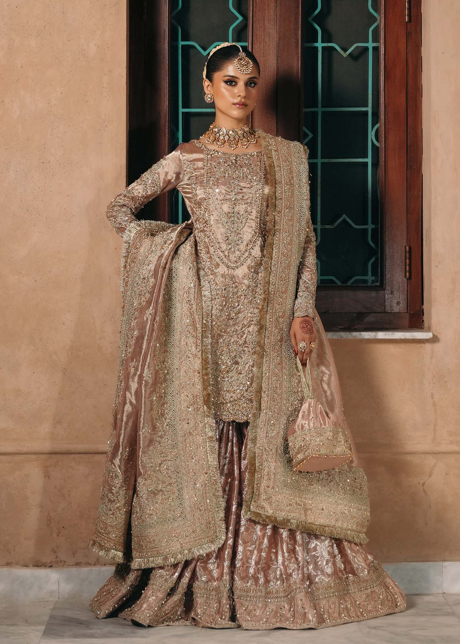 Model wearing Nazo by Kanwal Malik in dusty rose with gold embellishments – elegant Pakistani luxury pret for weddings in the UK.