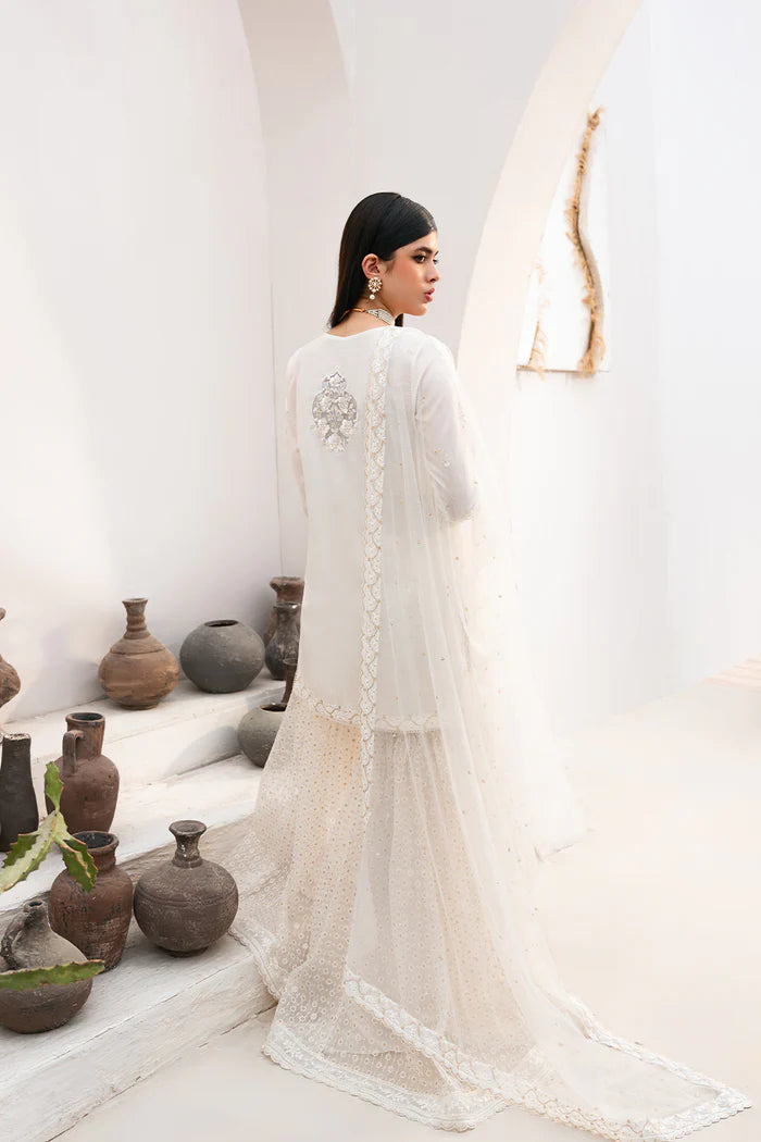 Model wearing Saira Rizwan Amaya dress, elegant white Pakistani clothes UK, detailed Eid wear.