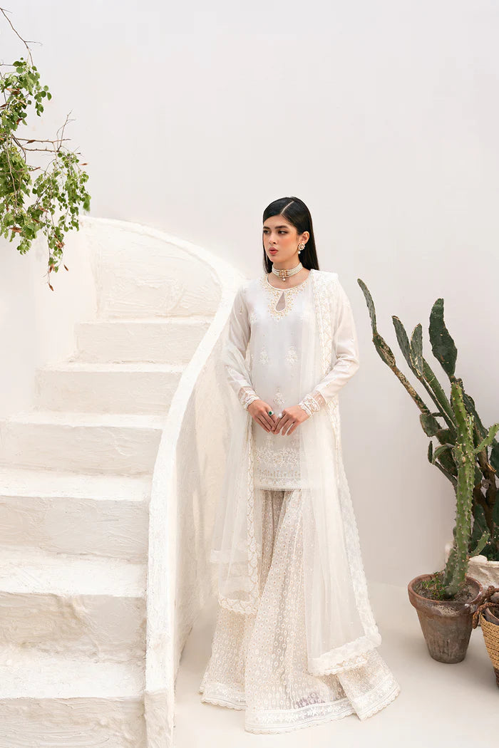 Model wearing Saira Rizwan Amaya dress, elegant white Pakistani clothes UK, detailed Eid wear.