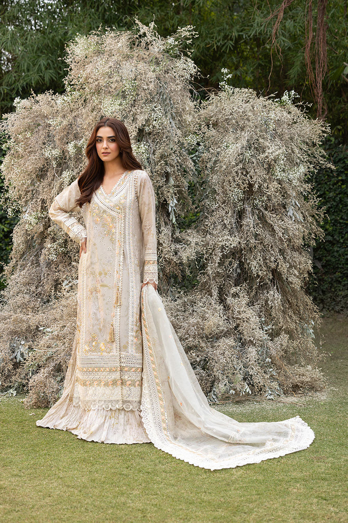 Model wearing Sobia Nazir Design 13B ivory luxury lawn dress with intricate embroidery. Shop Pakistani clothes online in the UK for casual and festive wear.