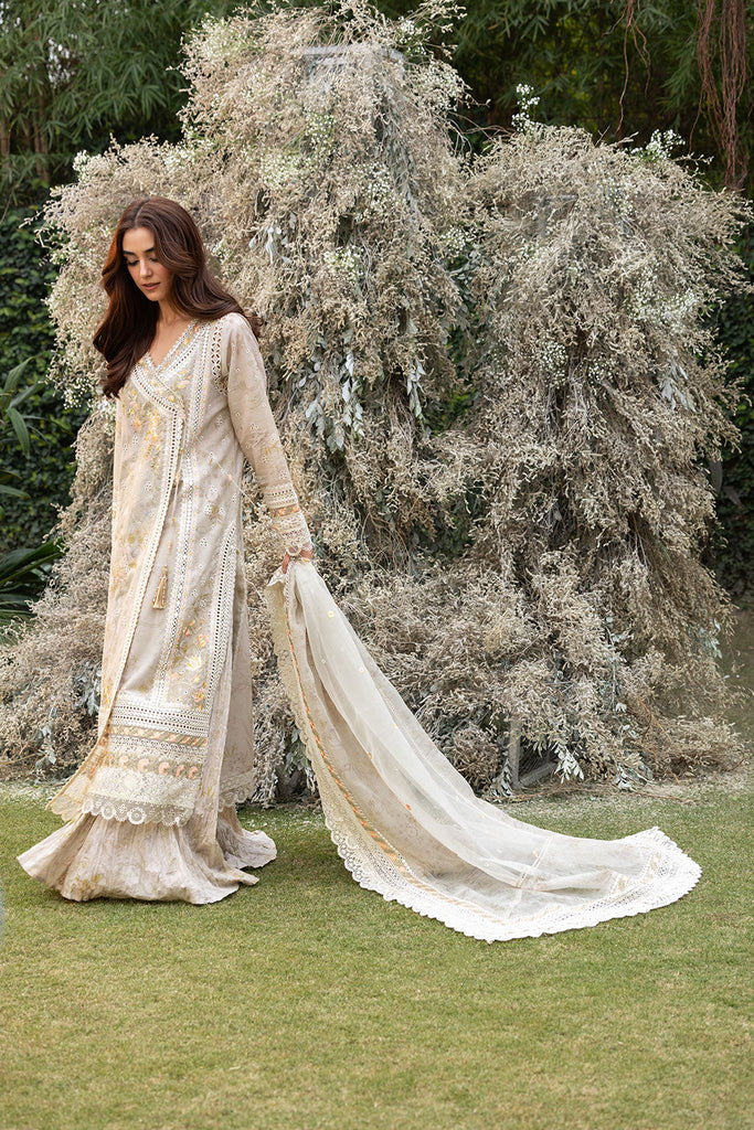 Model wearing Sobia Nazir Design 13B ivory luxury lawn dress with intricate embroidery. Shop Pakistani clothes online in the UK for casual and festive wear.