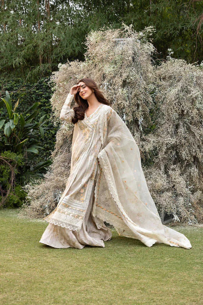 Model wearing Sobia Nazir Design 13B ivory luxury lawn dress with intricate embroidery. Shop Pakistani clothes online in the UK for casual and festive wear.