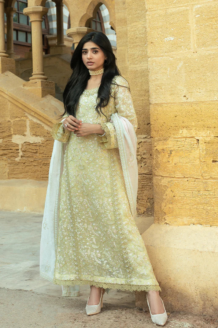 Model wearing Mushq Saugaat City of Lights Faryal in lime yellow with intricate embroidery and a white dupatta. Shop Pakistani luxury pret online in the UK.