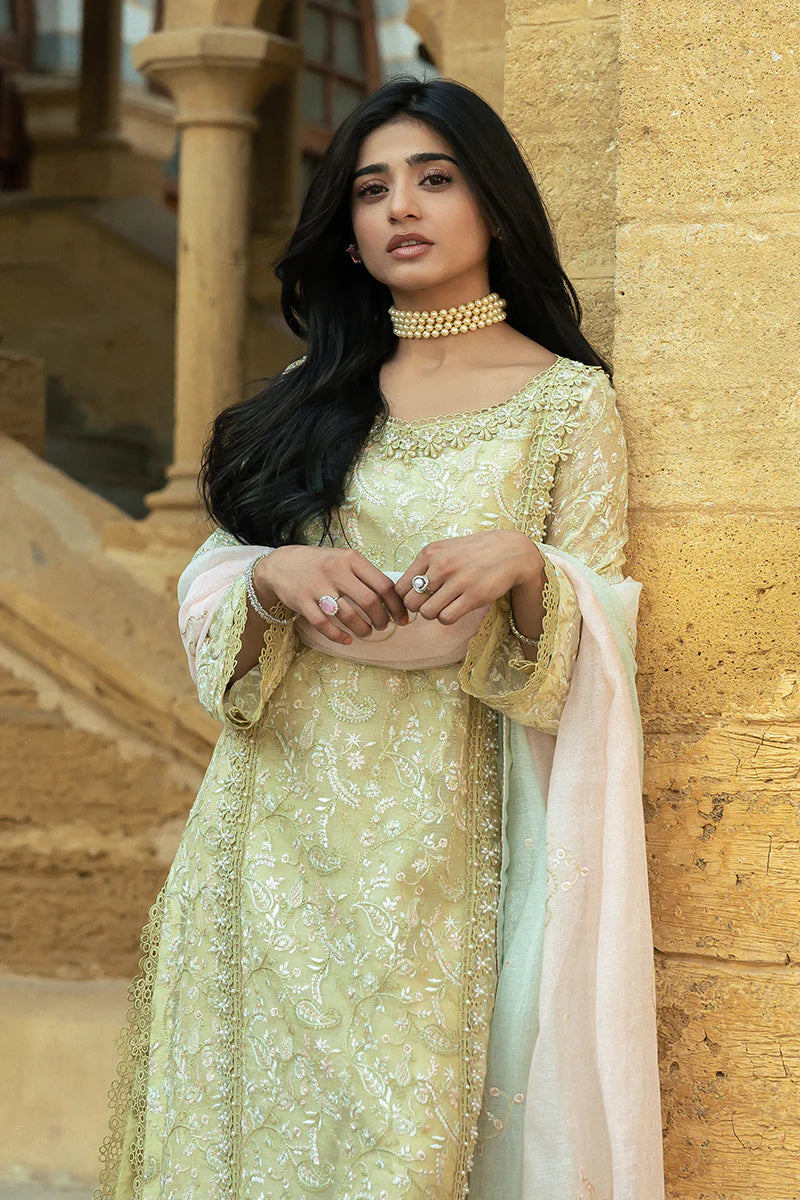 Model wearing Mushq Saugaat City of Lights Faryal in lime yellow with intricate embroidery and a white dupatta. Shop Pakistani luxury pret online in the UK.