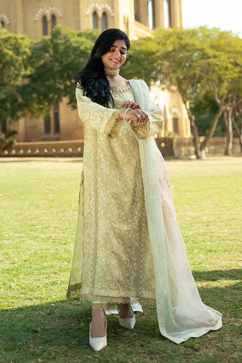 Model wearing Mushq Saugaat City of Lights Faryal in lime yellow with intricate embroidery and a white dupatta. Shop Pakistani luxury pret online in the UK.