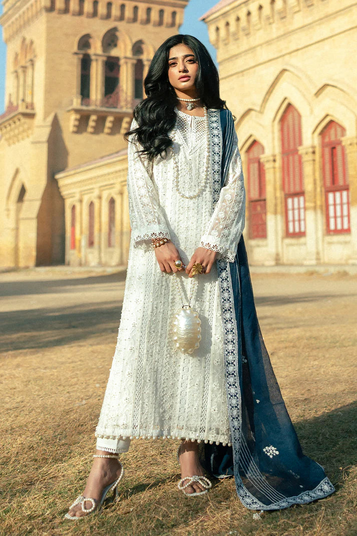 Model wearing Mushq Saugaat City of Lights Roshni in white with navy dupatta and lace details. Shop Pakistani luxury pret online in the UK.