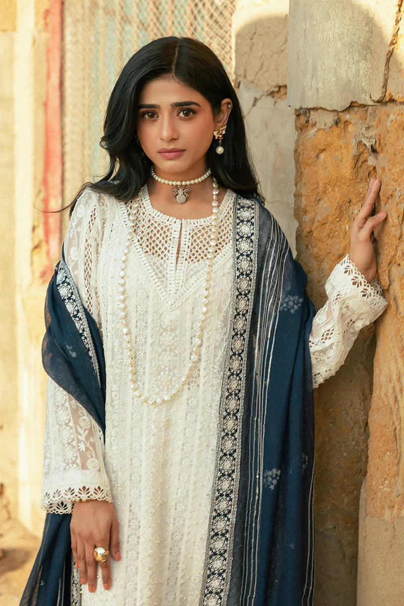 Model wearing Mushq Saugaat City of Lights Roshni in white with navy dupatta and lace details. Shop Pakistani luxury pret online in the UK.