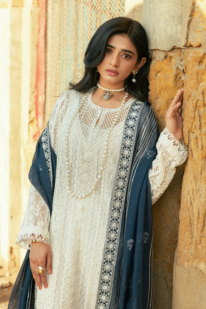 Model wearing Mushq Saugaat City of Lights Roshni in white with navy dupatta and lace details. Shop Pakistani luxury pret online in the UK.