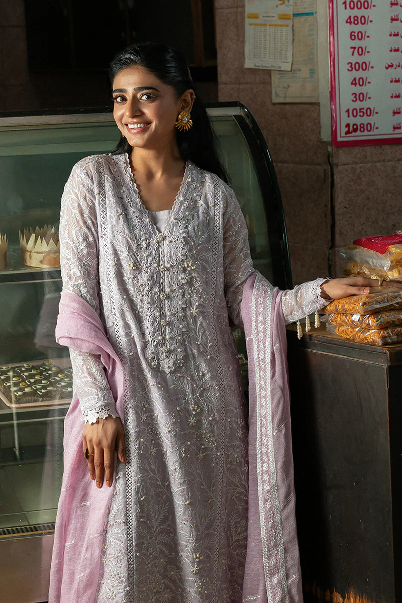 Model wearing Mushq Saugaat City of Lights Andaleeb in soft lilac with delicate embroidery and a pink dupatta. Shop Pakistani luxury pret online in the UK.