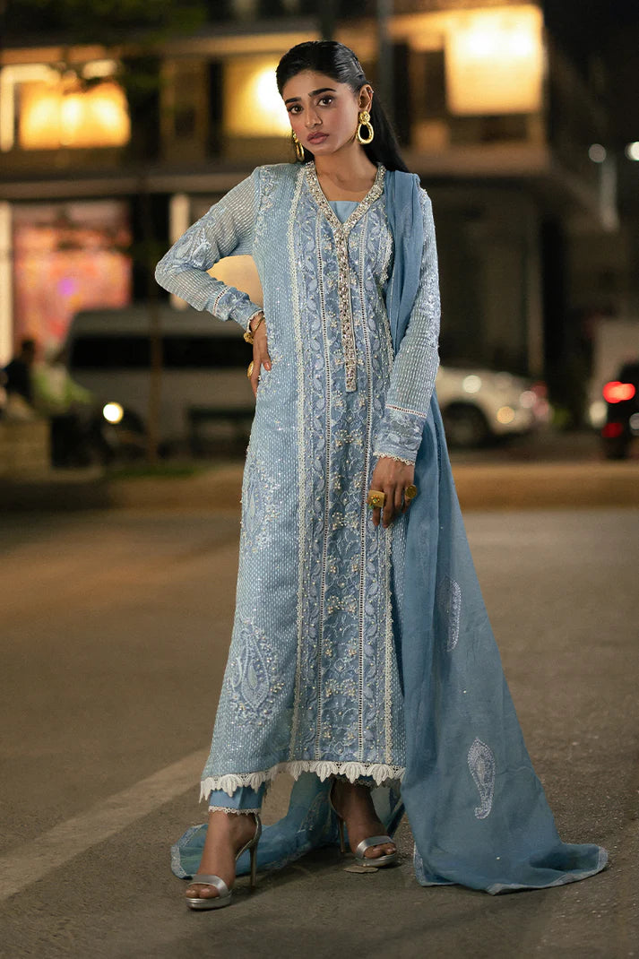 Model wearing Mushq Saugaat City of Lights Umeed in pastel blue with intricate embellishments. Shop Pakistani luxury pret online in the UK.