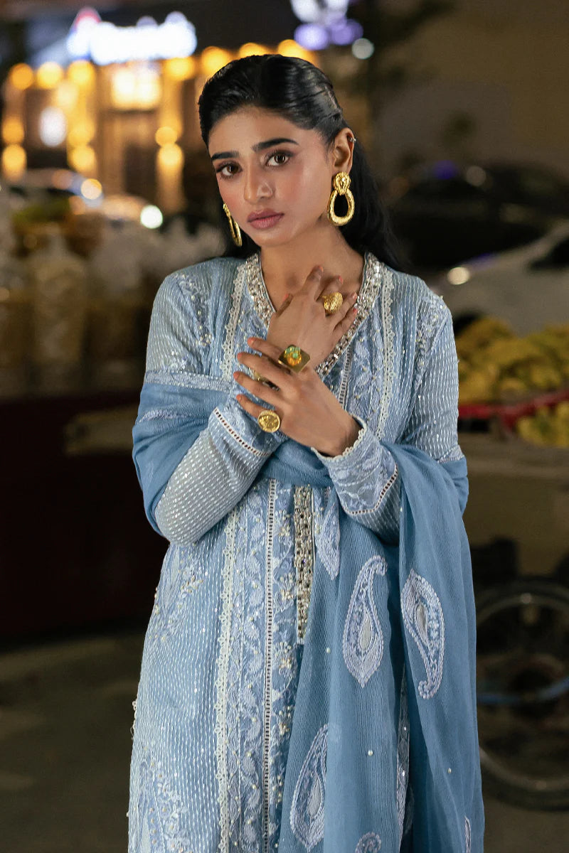 Model wearing Mushq Saugaat City of Lights Umeed in pastel blue with intricate embellishments. Shop Pakistani luxury pret online in the UK.