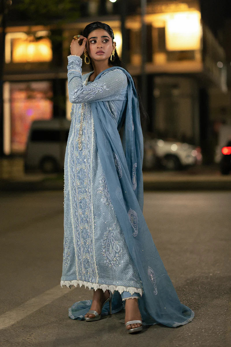 Model wearing Mushq Saugaat City of Lights Umeed in pastel blue with intricate embellishments. Shop Pakistani luxury pret online in the UK.