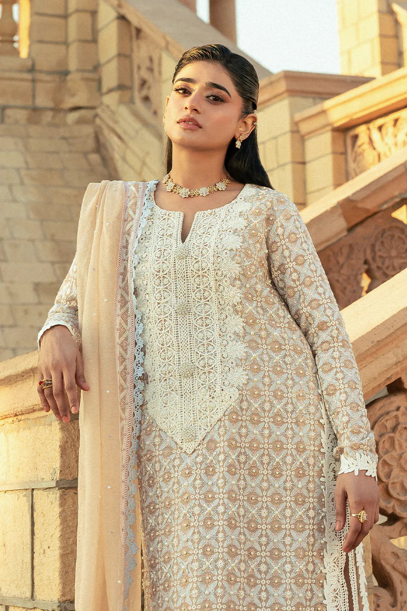 Model wearing Mushq Saugaat City of Lights Faria in beige with intricate embroidery. Shop Pakistani luxury pret online in the UK.
