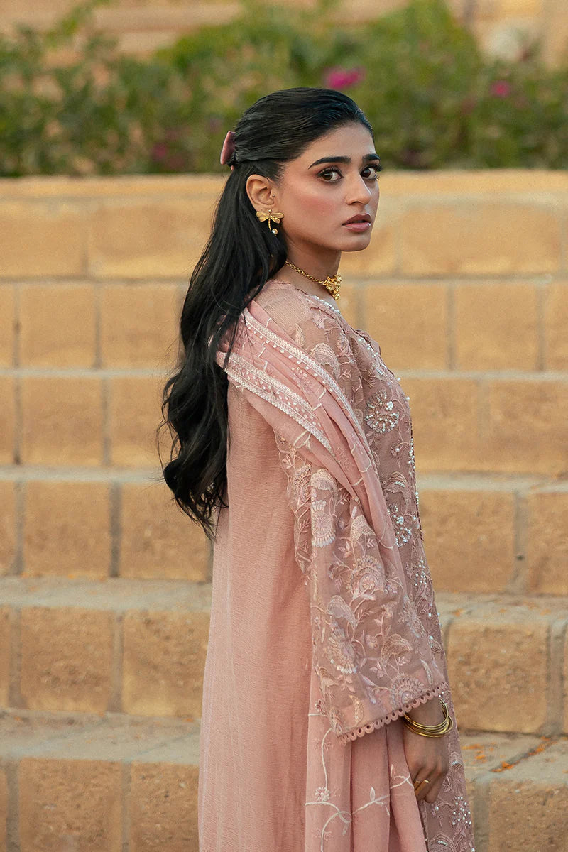 Model wearing Mushq Saugaat City of Lights Rabia in blush pink with delicate embroidery. Shop Pakistani luxury pret online in the UK.