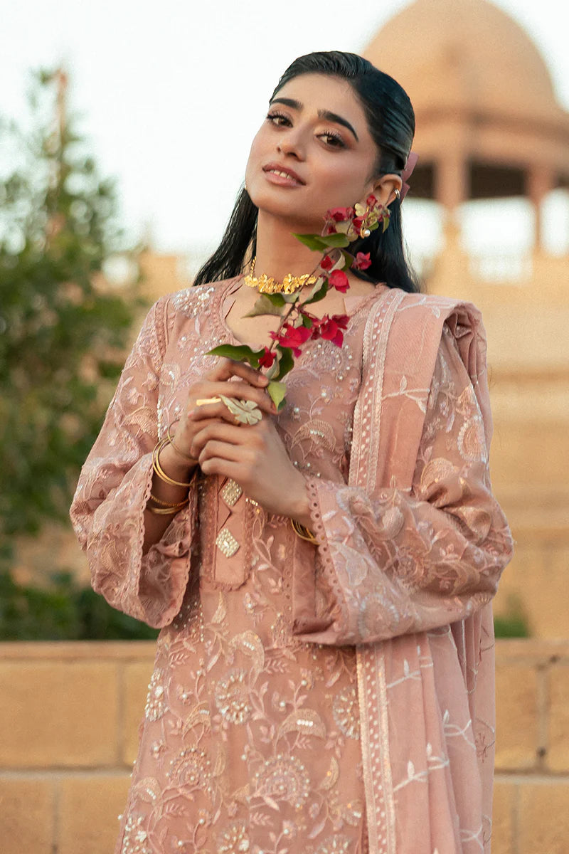 Model wearing Mushq Saugaat City of Lights Rabia in blush pink with delicate embroidery. Shop Pakistani luxury pret online in the UK.