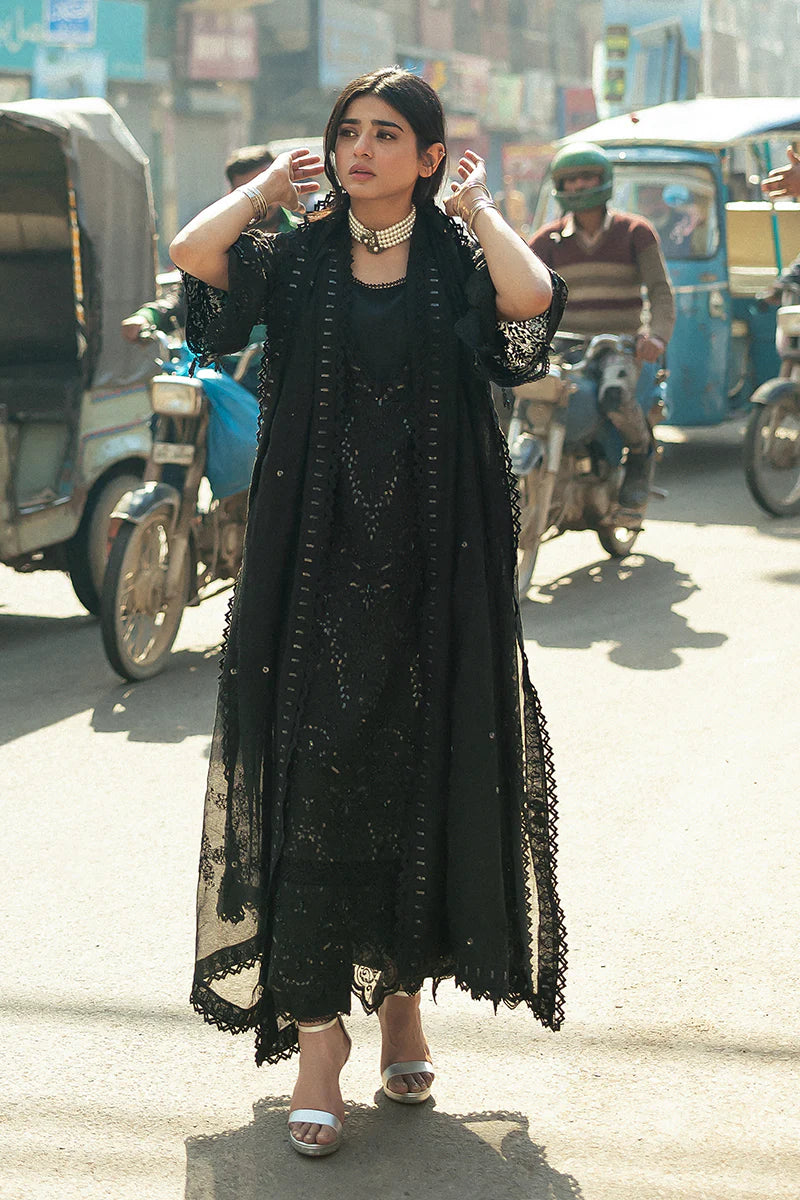 Model wearing Mushq Saugaat City of Lights Rija in black with intricate embellishments. Shop Pakistani luxury pret online in the UK.