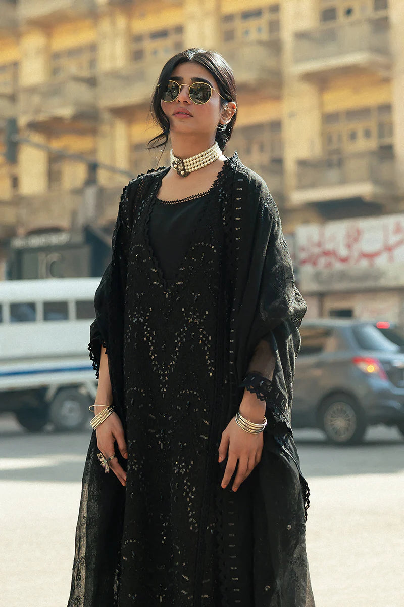 Model wearing Mushq Saugaat City of Lights Rija in black with intricate embellishments. Shop Pakistani luxury pret online in the UK.