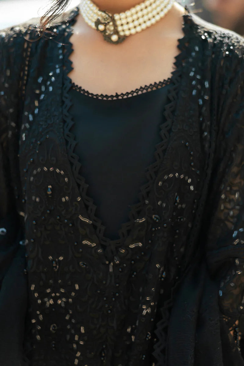 Model wearing Mushq Saugaat City of Lights Rija in black with intricate embellishments. Shop Pakistani luxury pret online in the UK.