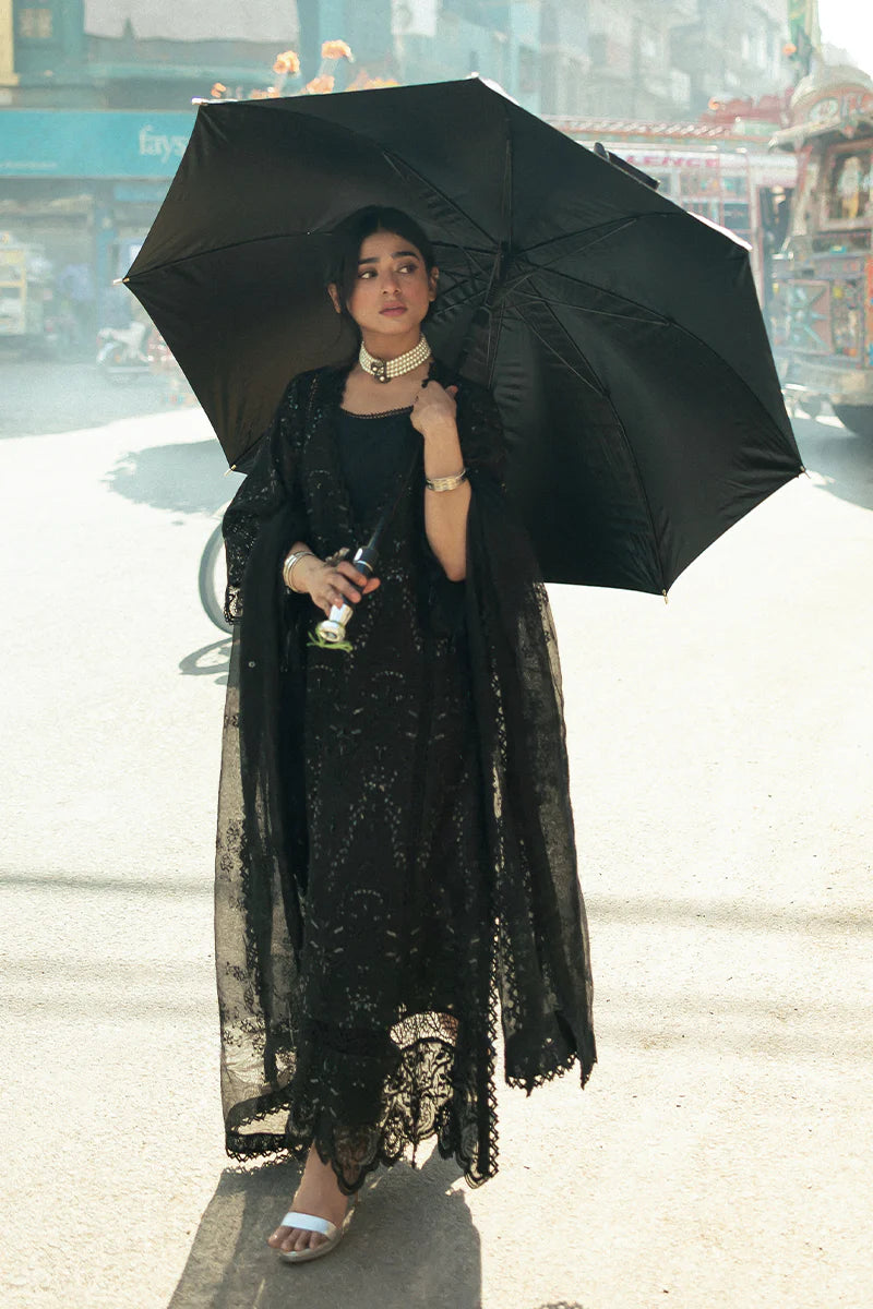Model wearing Mushq Saugaat City of Lights Rija in black with intricate embellishments. Shop Pakistani luxury pret online in the UK.