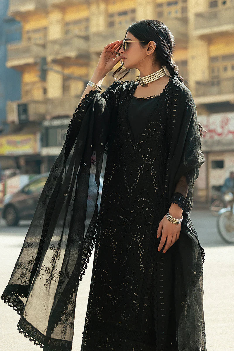 Model wearing Mushq Saugaat City of Lights Rija in black with intricate embellishments. Shop Pakistani luxury pret online in the UK.