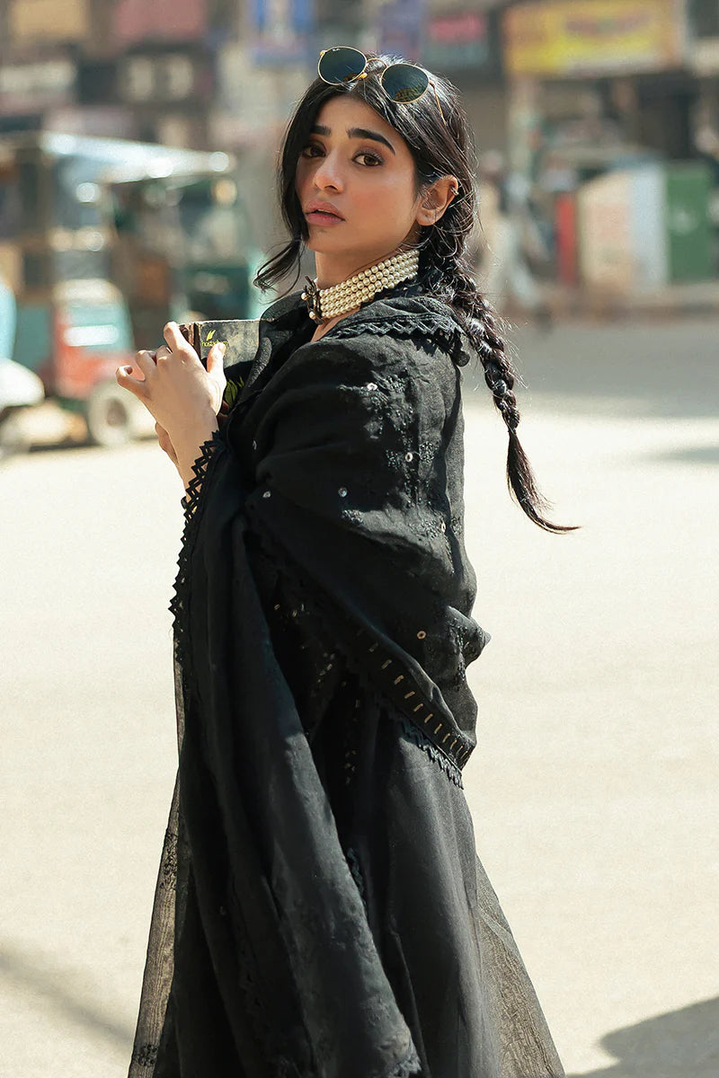 Model wearing Mushq Saugaat City of Lights Rija in black with intricate embellishments. Shop Pakistani luxury pret online in the UK.
