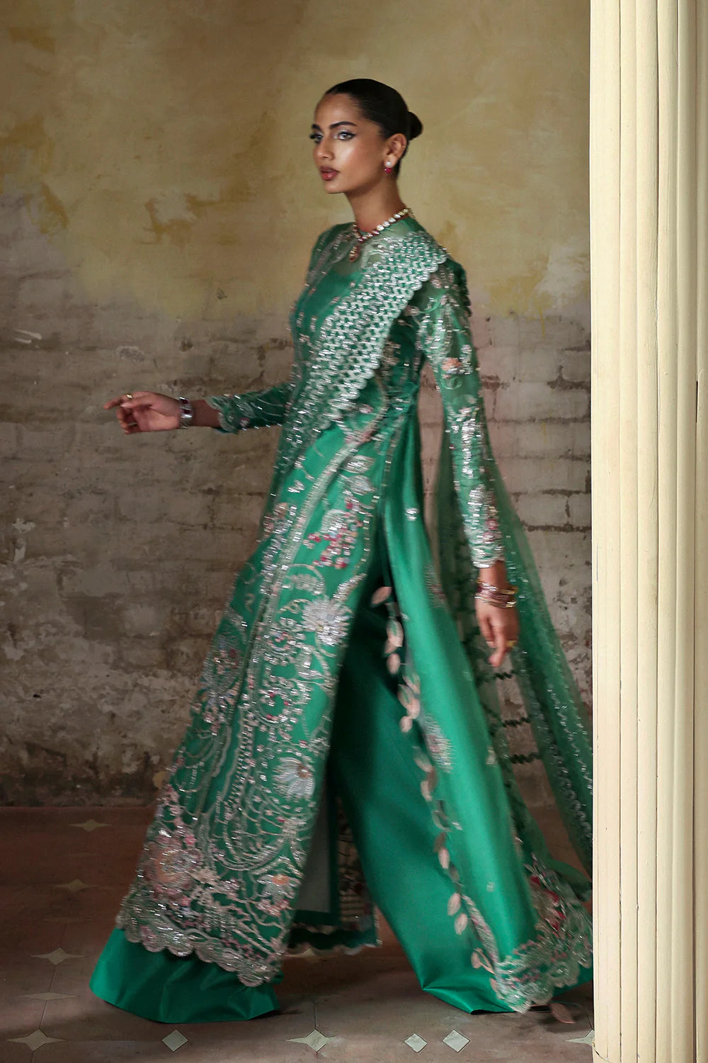 Model wearing Maristella by Soraya in emerald green with silver embellishments – Pakistani luxury pret, shop Soraya clothes online in UK.
