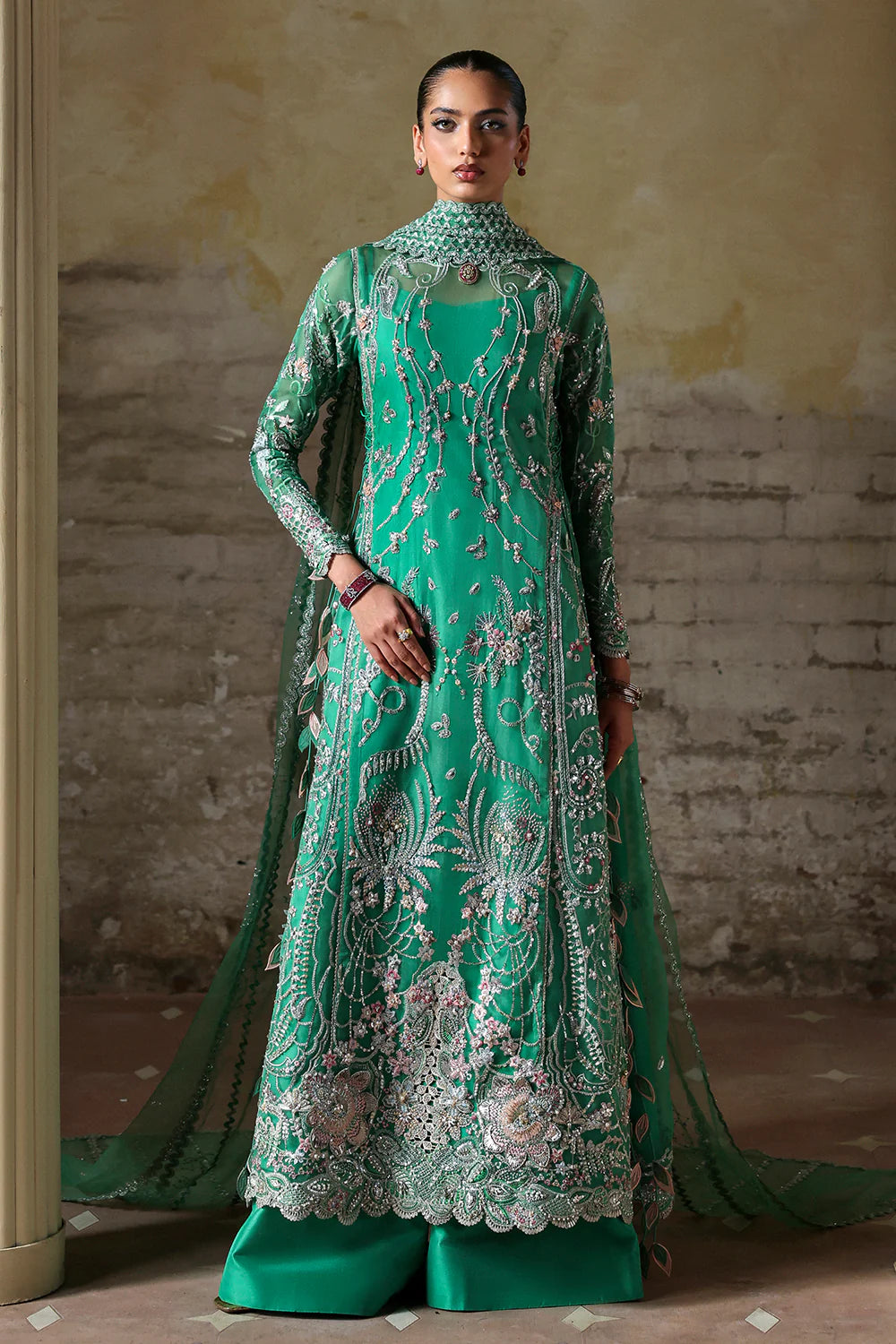 Model wearing Maristella by Soraya in emerald green with silver embellishments – Pakistani luxury pret, shop Soraya clothes online in UK.
