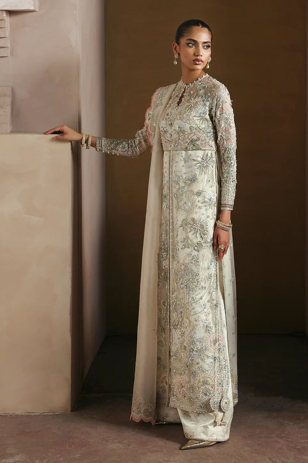 Model wearing Novara by Soraya in ivory with silver and pastel embroidery – Pakistani luxury pret, shop Soraya clothes online in UK.
