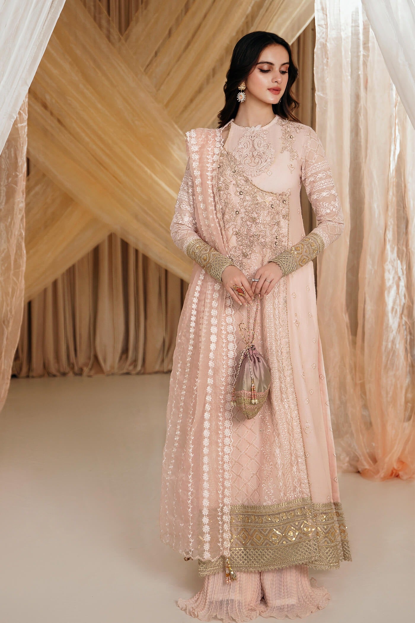 Model wearing Faiza Saqlain's Rose dress from the Musferah Saad Mystere Eid Collection '24. A soft pink Pakistani Eid dress with intricate gold embroidery, perfect for Pakistani designer clothes shoppers in the UK.