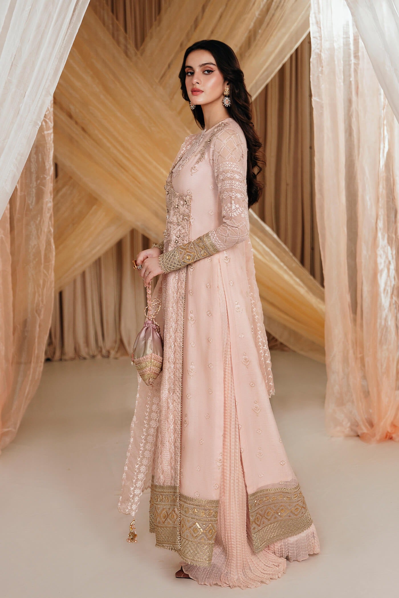 Model wearing Faiza Saqlain's Rose dress from the Musferah Saad Mystere Eid Collection '24. A soft pink Pakistani Eid dress with intricate gold embroidery, perfect for Pakistani designer clothes shoppers in the UK.