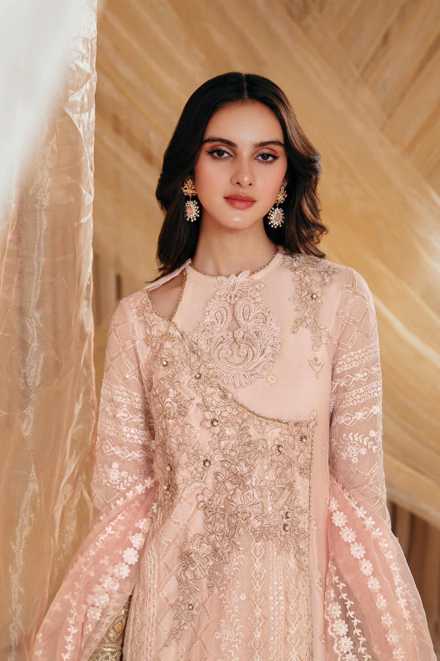 Model wearing Faiza Saqlain's Rose dress from the Musferah Saad Mystere Eid Collection '24. A soft pink Pakistani Eid dress with intricate gold embroidery, perfect for Pakistani designer clothes shoppers in the UK.