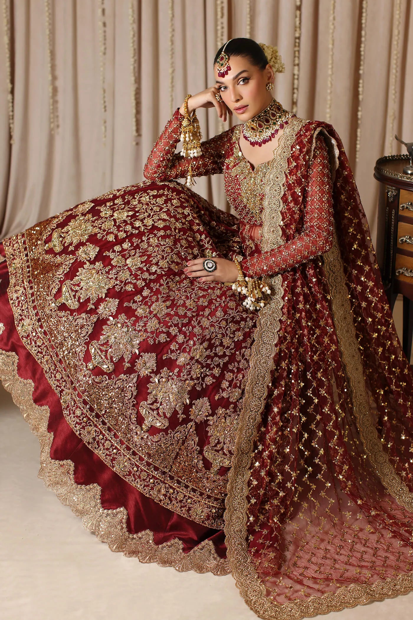 Model wearing a maroon MAHARANI dress from Musferah Saad's The Modern Maharani '23 collection, showcasing Pakistani clothes online in the UK.